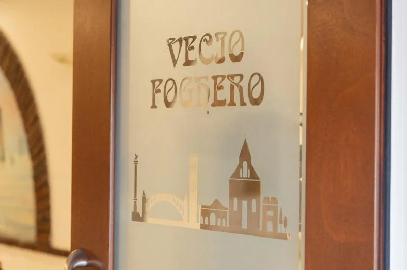 Insegna del ristorante Vecio Foghero sullo sfondo dello skyline storico di Chioggia
